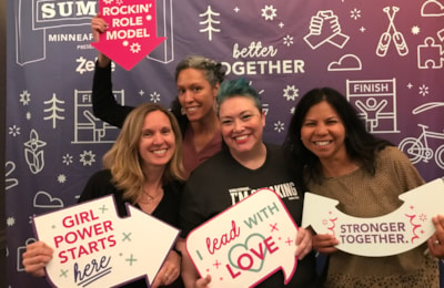 Staff hold up signs during the 2022 Girls on the Run Summit